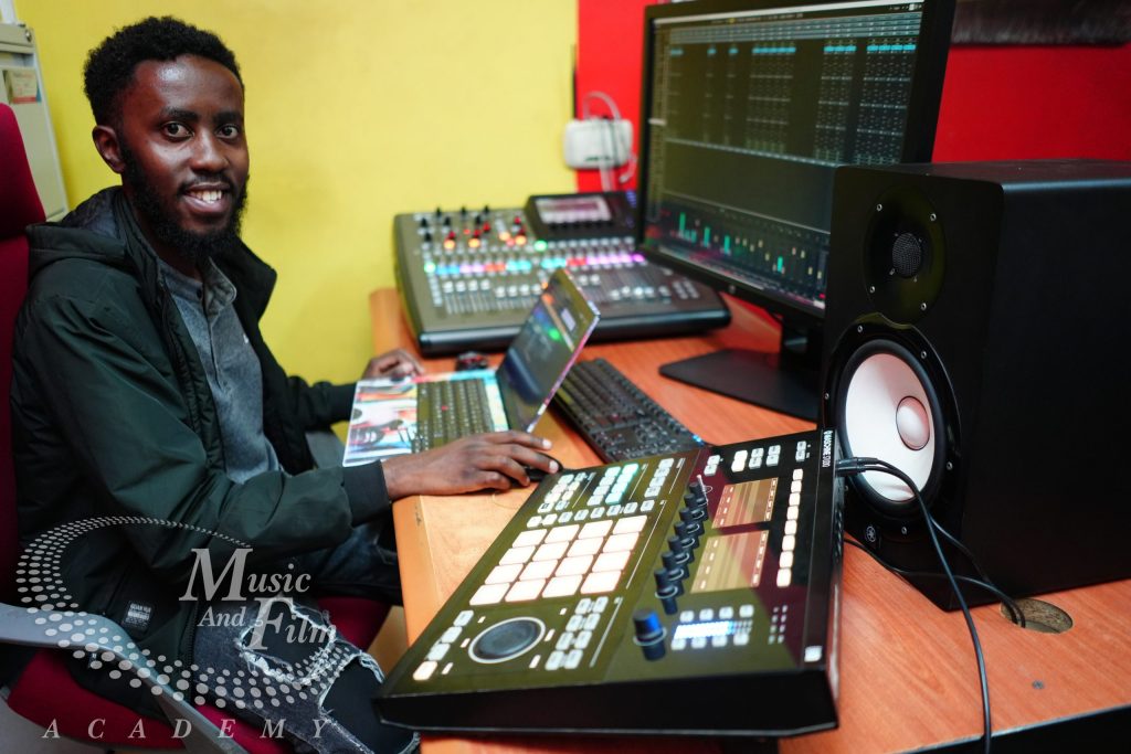 Student producer editing a music production project on a DAW inside the Music and Film Academy studio in Nairobi.